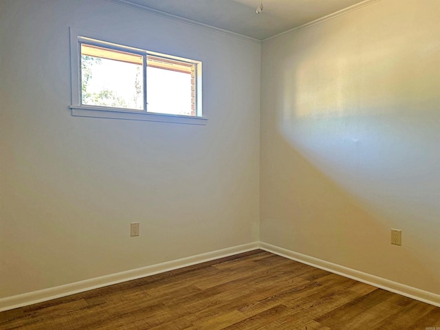 spare room with ornamental molding and wood-type flooring