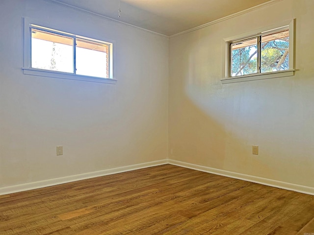 unfurnished room with a healthy amount of sunlight, wood-type flooring, and ornamental molding