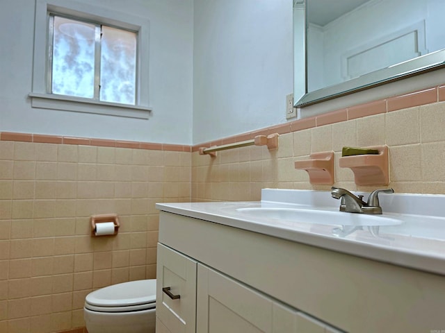 bathroom with tile walls, vanity, and toilet