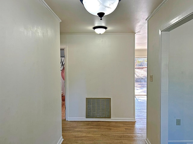 corridor featuring ornamental molding and wood-type flooring