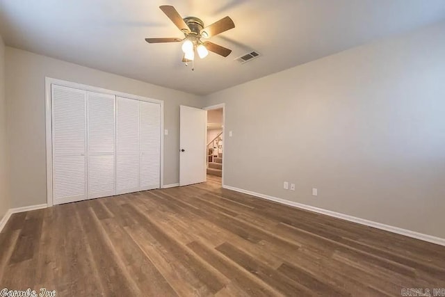 unfurnished bedroom with a closet, dark wood-type flooring, and ceiling fan