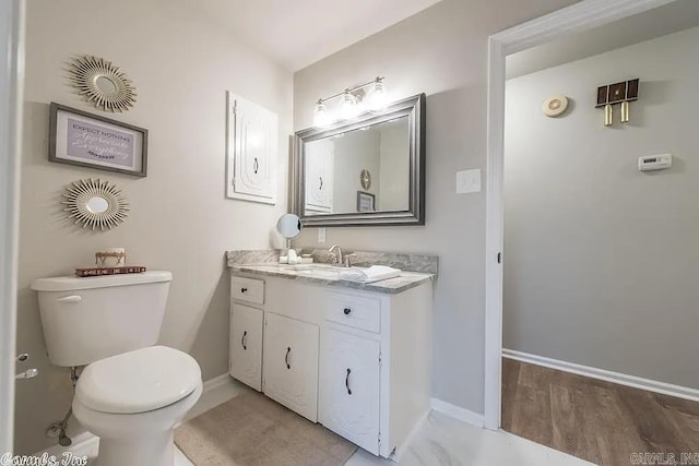 bathroom with toilet, hardwood / wood-style flooring, and vanity