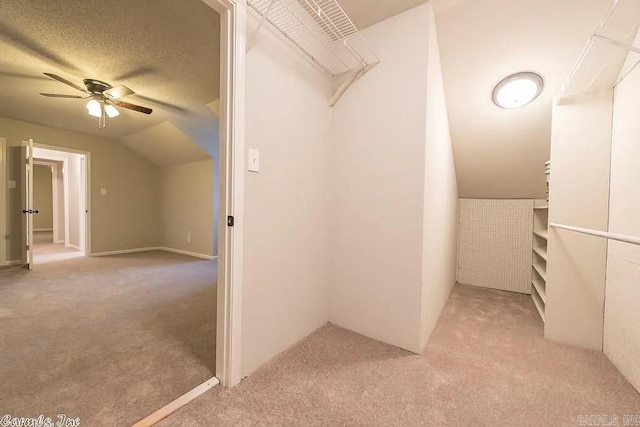 walk in closet with lofted ceiling, light carpet, and ceiling fan