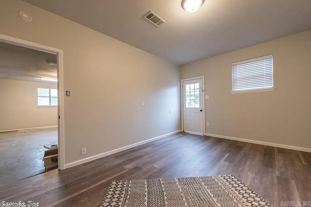 spare room featuring lofted ceiling and dark hardwood / wood-style floors