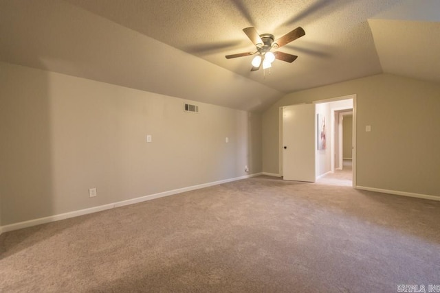 bonus room featuring a textured ceiling, ceiling fan, carpet flooring, and vaulted ceiling