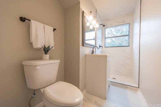 bathroom with a tile shower and toilet