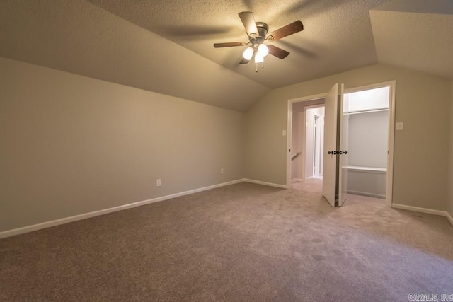 additional living space with lofted ceiling, carpet, a textured ceiling, and ceiling fan