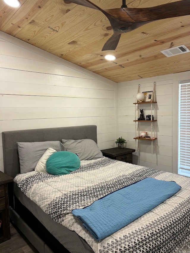 bedroom featuring vaulted ceiling, wood ceiling, hardwood / wood-style flooring, and wood walls