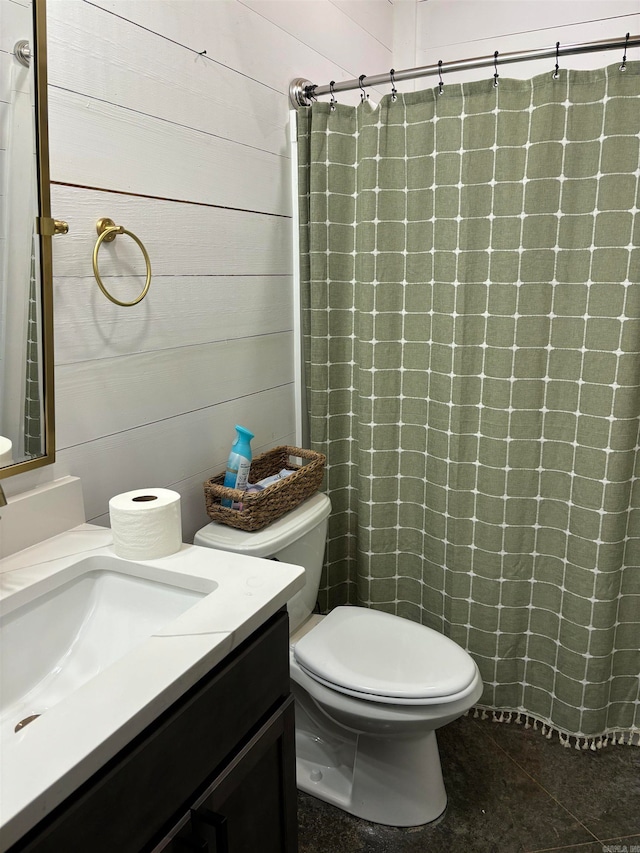 bathroom featuring a shower with shower curtain, toilet, tile patterned floors, wooden walls, and vanity