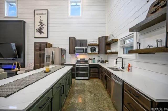 kitchen featuring a sink, dark brown cabinetry, appliances with stainless steel finishes, and open shelves