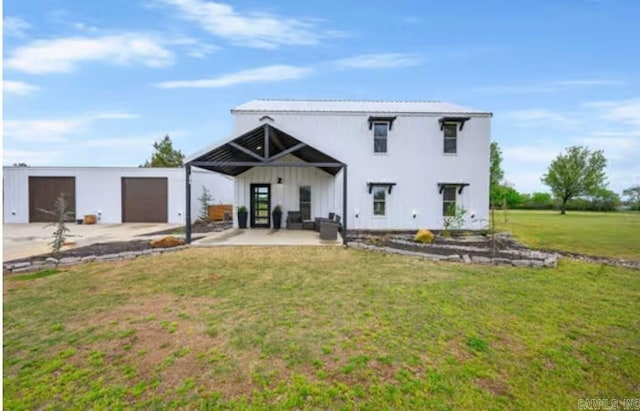 rear view of property with a lawn and a garage