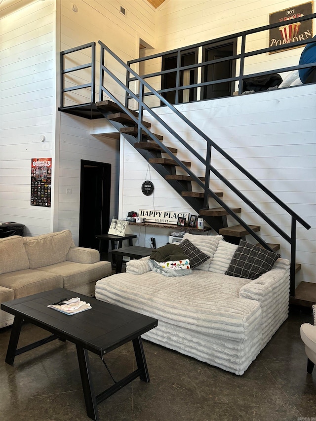 living room with a high ceiling and wooden walls