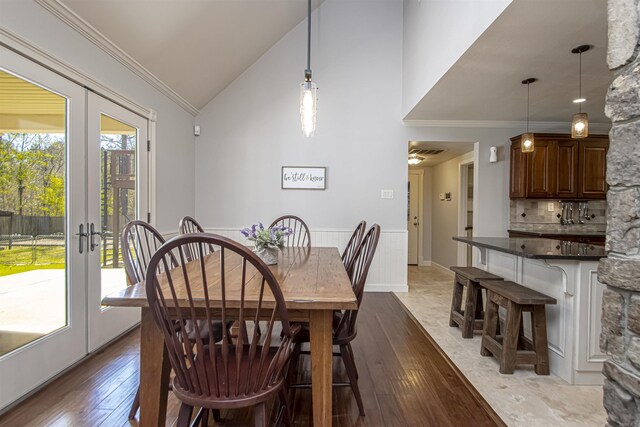 dining room featuring hardwood / wood-style floors, lofted ceiling, and ornamental molding