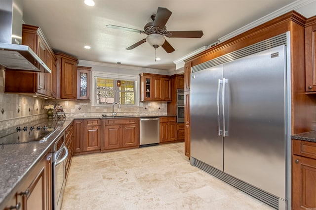 kitchen featuring decorative backsplash, hanging light fixtures, sink, wall chimney exhaust hood, and stainless steel appliances