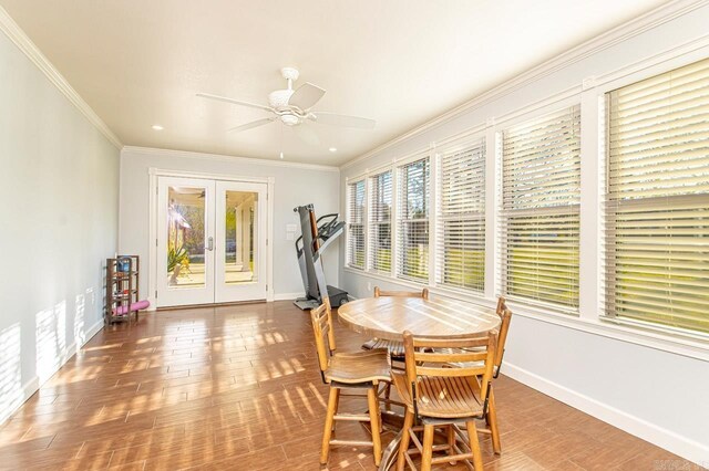 dining area with french doors, baseboards, wood finished floors, ceiling fan, and ornamental molding