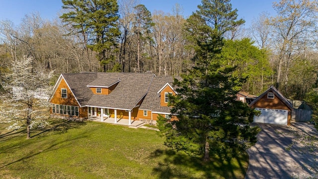 view of front of property featuring a garage, a front lawn, and an outdoor structure