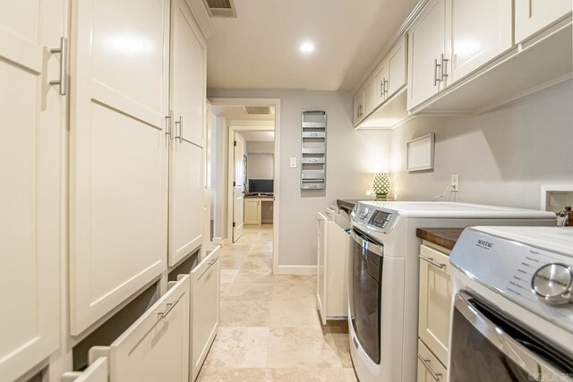washroom featuring washing machine and dryer, visible vents, baseboards, and recessed lighting