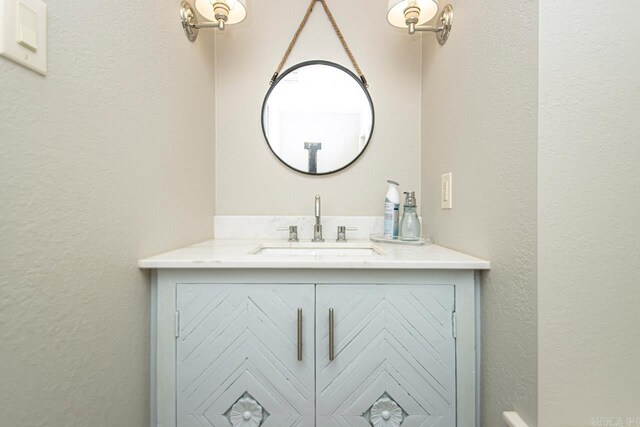 bathroom featuring a textured wall and vanity
