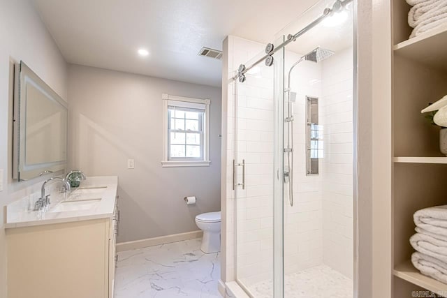 bathroom with vanity, toilet, and a shower with shower door