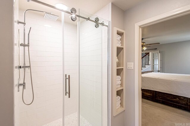 bathroom with a shower stall and a ceiling fan