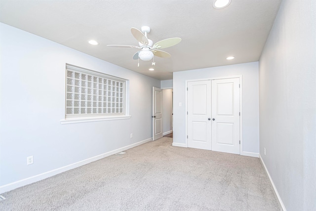 unfurnished bedroom with a closet, ceiling fan, and light colored carpet