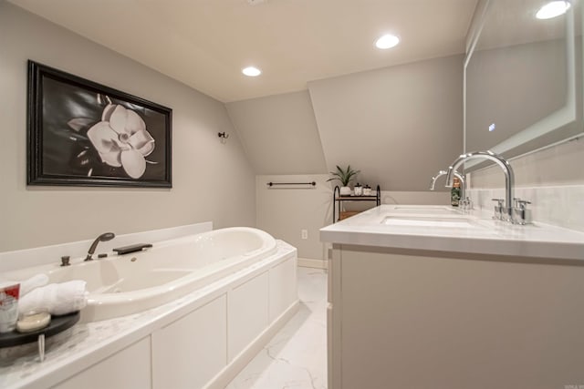 bathroom with vanity, lofted ceiling, and a tub