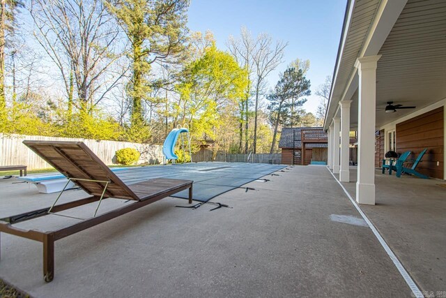 rear view of property with a lawn, fence, an outbuilding, and a patio