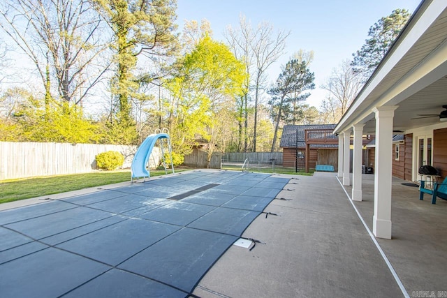 view of swimming pool featuring a water slide, a patio area, and ceiling fan