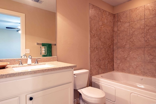 full bathroom with vanity, tiled shower / bath combo, and toilet