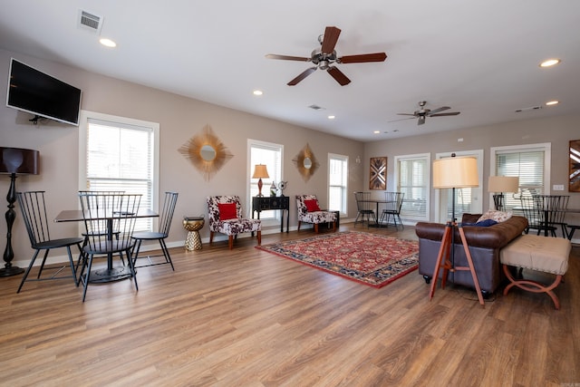 living room featuring light wood-type flooring, a healthy amount of sunlight, and ceiling fan