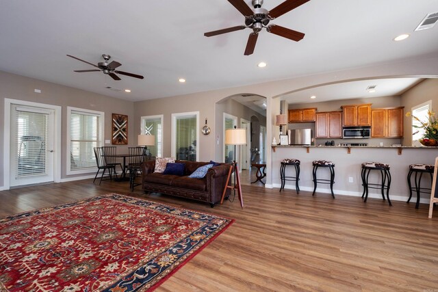 living room with light hardwood / wood-style floors and ceiling fan