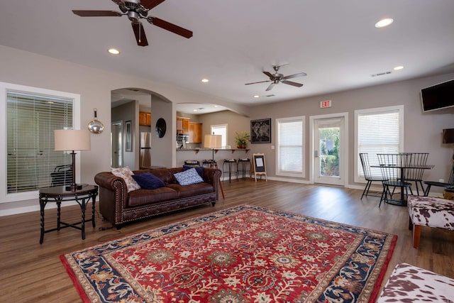 living room with wood-type flooring and ceiling fan