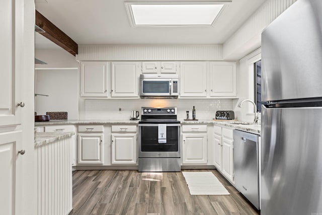 kitchen with white cabinetry, light hardwood / wood-style floors, stainless steel appliances, and sink