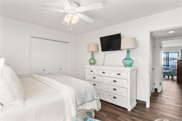 bedroom with a closet, ceiling fan, and dark hardwood / wood-style floors