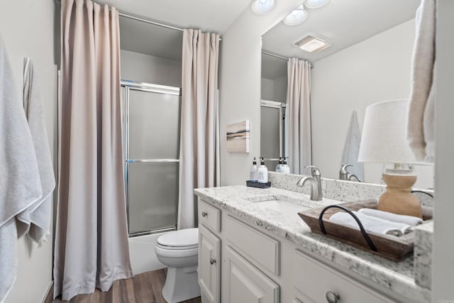 full bathroom featuring vanity, hardwood / wood-style floors, shower / bath combination with curtain, and toilet