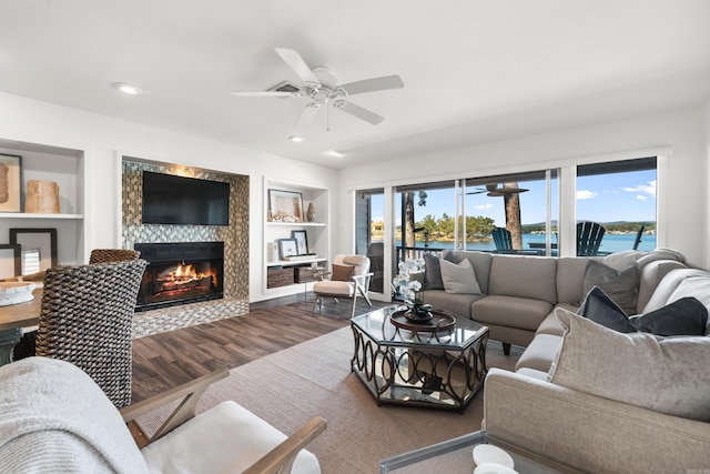 living room with ceiling fan, a fireplace, built in features, and dark hardwood / wood-style flooring