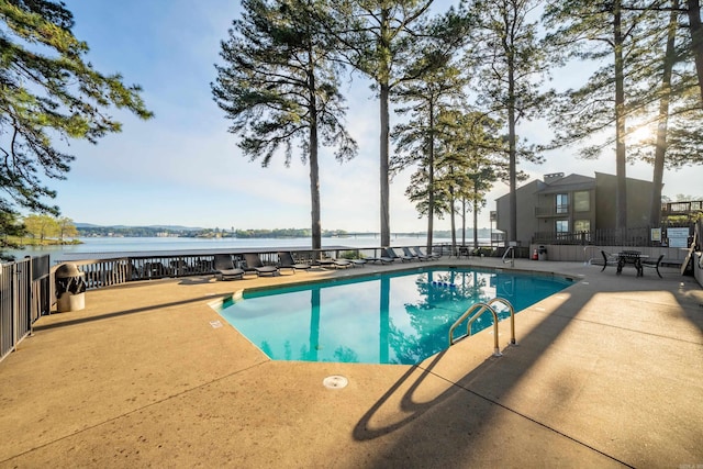 view of swimming pool featuring a patio area and a water view