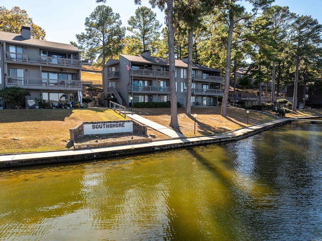 dock area with a water view and a balcony