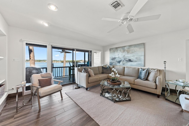 living room featuring plenty of natural light, hardwood / wood-style flooring, a water view, and ceiling fan