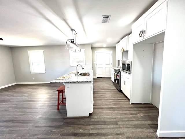 kitchen featuring dark hardwood / wood-style flooring, white cabinets, sink, and pendant lighting