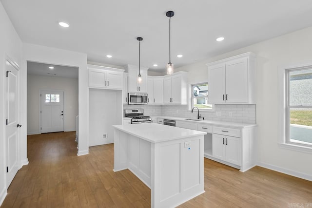 kitchen with sink, a center island, white cabinetry, stainless steel appliances, and a wealth of natural light