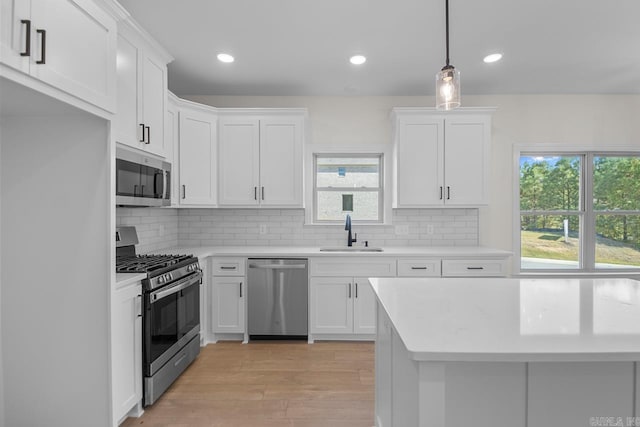 kitchen featuring white cabinetry, appliances with stainless steel finishes, sink, and plenty of natural light