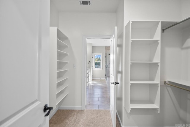 spacious closet featuring light carpet