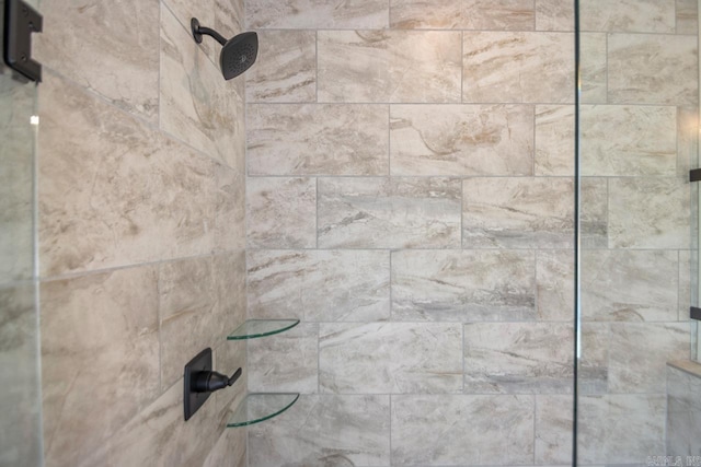 interior details featuring a tile shower