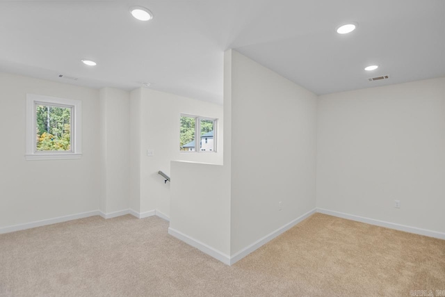 spare room featuring light colored carpet