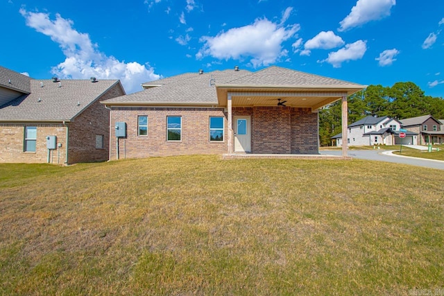 rear view of house with a yard and ceiling fan