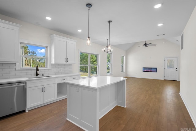 kitchen featuring sink, dishwasher, a center island, white cabinetry, and lofted ceiling