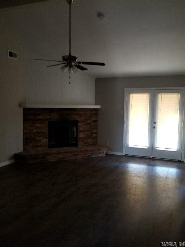 unfurnished living room featuring lofted ceiling, ceiling fan, hardwood / wood-style flooring, a fireplace, and french doors