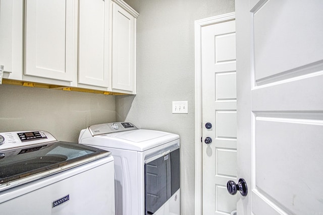 laundry area with washer and clothes dryer and cabinets