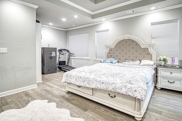 bedroom with ornamental molding and light hardwood / wood-style flooring